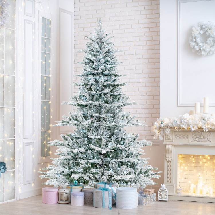 Snow flocked 7 feet artificial Christmas tree with cool white LED lights, perfect for festive home decor.