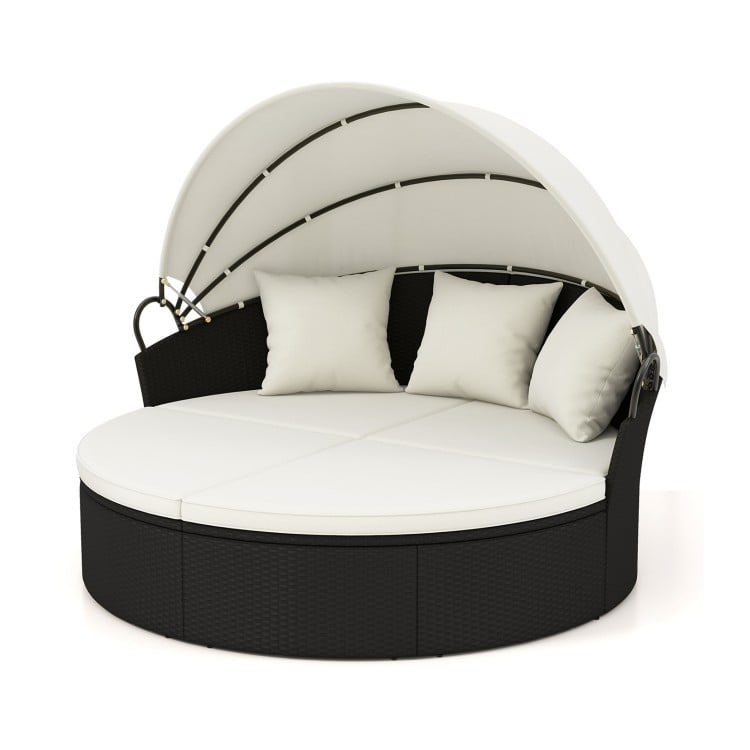 Round patio daybed with retractable canopy and off-white cushions, made of durable PE rattan for outdoor relaxation.