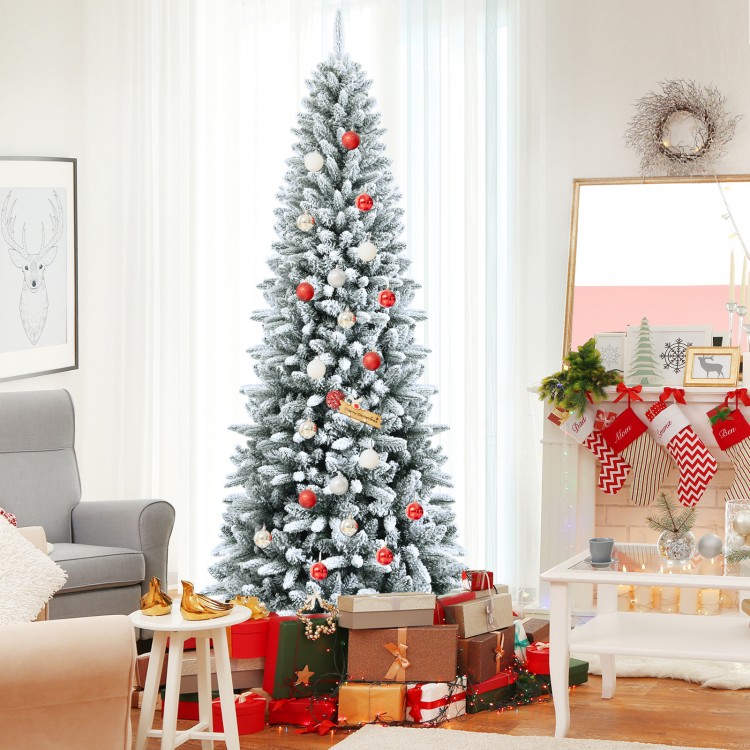 Snow-flocked 7.5' artificial Christmas pencil tree with mixed tips, decorated with ornaments and surrounded by gifts.