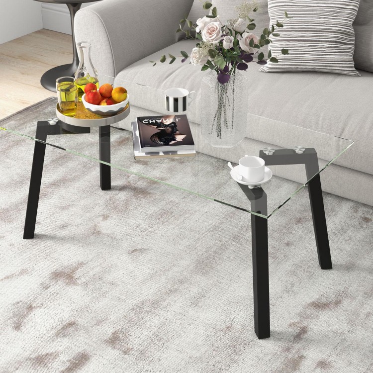 Modern tempered glass coffee table with black metal frame, featuring a spacious top for living room use.