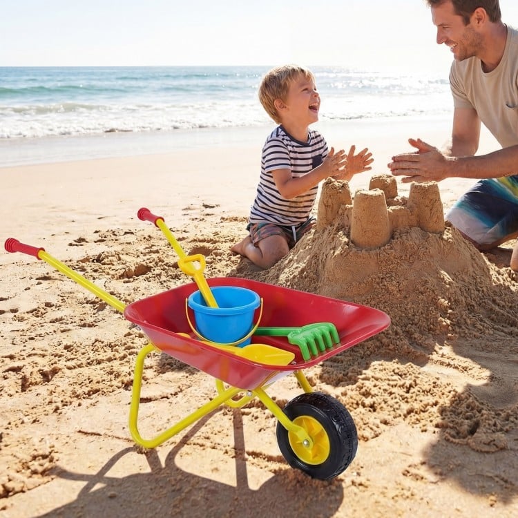 Kids wheelbarrow in red with all-terrain wheels, perfect for hauling toys and sand at the beach for outdoor fun.