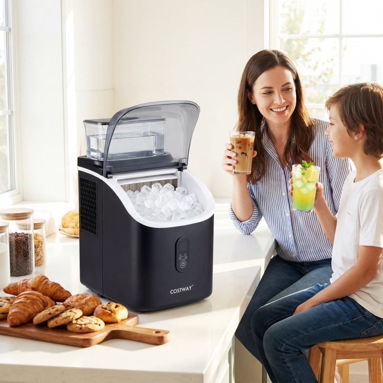 Countertop ice maker in black with external tank, making ice cubes while a woman and child enjoy drinks at a kitchen.