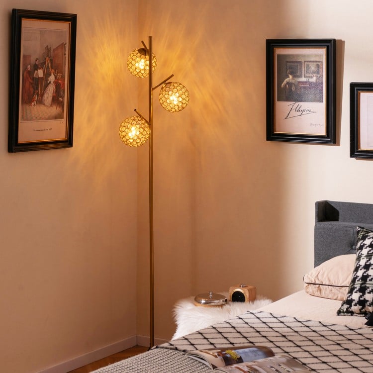 Three-globe floor lamp with golden finish, acrylic shades, foot switch, ideal for home or cafe lighting.