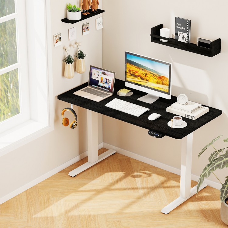 Electric standing desk in black with height adjustment, memory settings, and spacious tabletop for organized workspace.