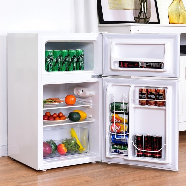 Compact stainless steel refrigerator with adjustable shelves, crisper drawer, and separate freezer for organized food.