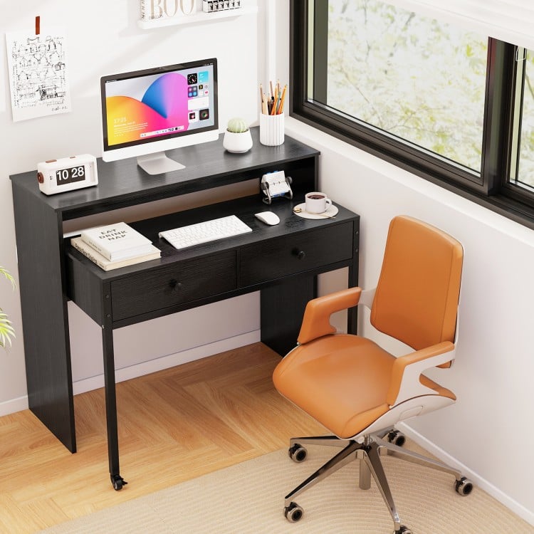 Extendable black computer desk with two storage drawers and monitor shelf, ideal for home office or study use.