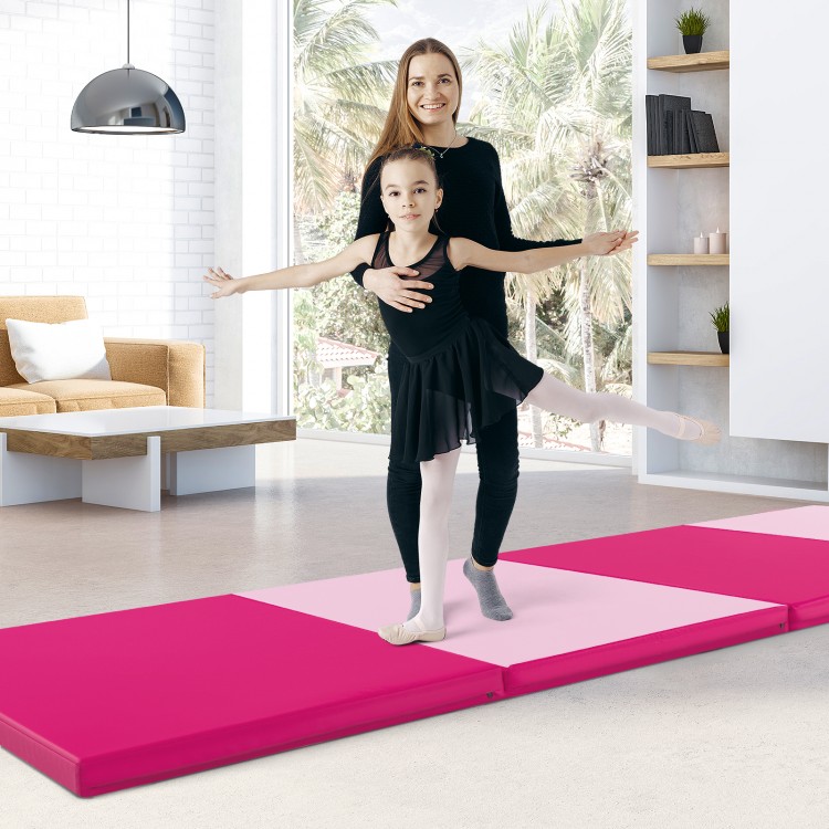 Folding exercise mat in hot pink, featuring four panels and carrying handles, ideal for gymnastics and stretching.