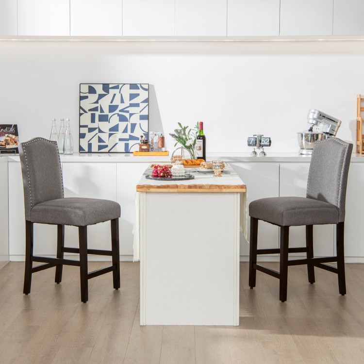 Gray fabric counter height dining side chairs with rubberwood legs and nail head design, perfect for kitchens or bars.