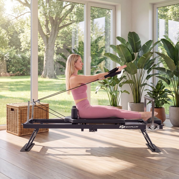 Foldable Pilates reformer machine in black with adjustable footbar and dual resistance for versatile home workouts.