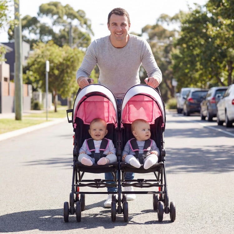 Foldable twin baby double stroller in pink, featuring a lightweight frame and ventilated canopy, perfect for travel.