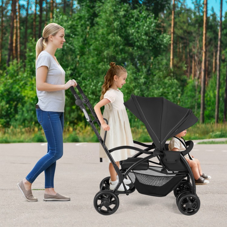 Foldable twin tandem stroller in black with adjustable handlebar, accommodating younger and older kids for outdoor use.
