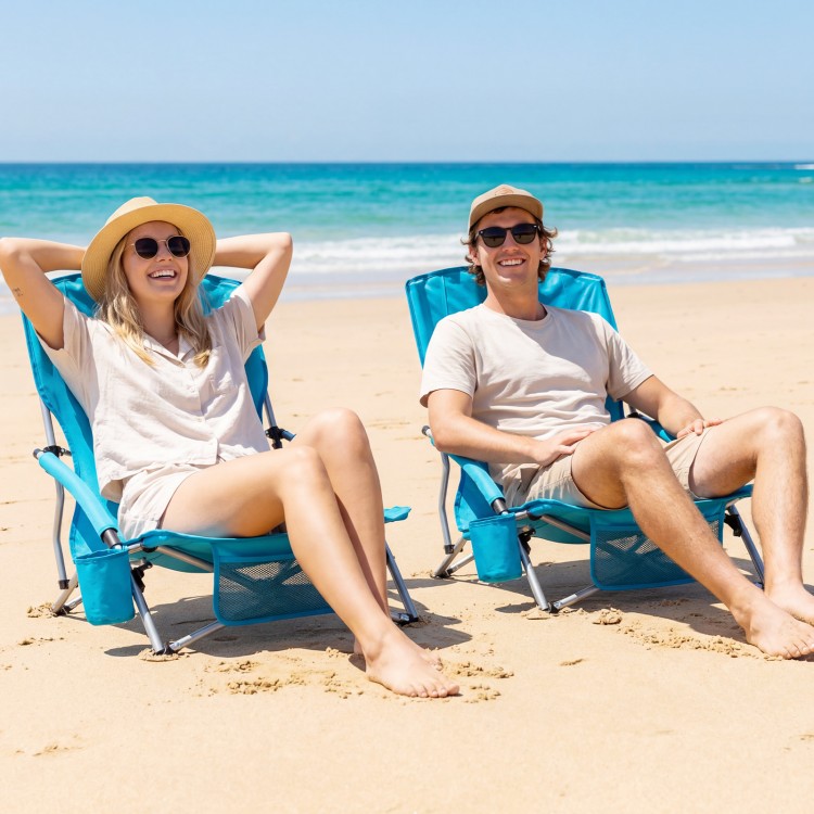 Two blue folding beach chairs with padded armrests on the sand, perfect for outdoor relaxation and convenience.