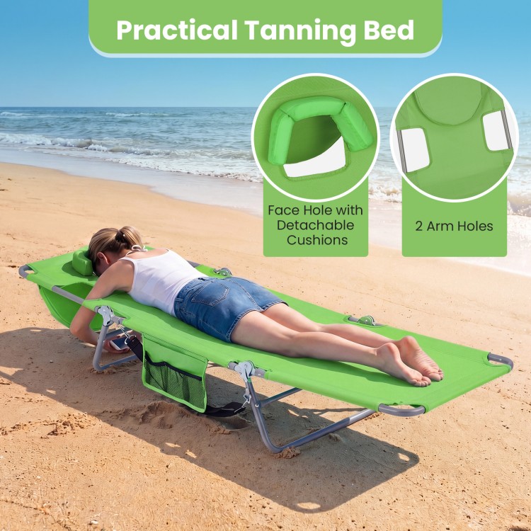 Folding beach lounge chair in lawn-green with adjustable backrest, face hole, and arm holes for hands-free relaxation.