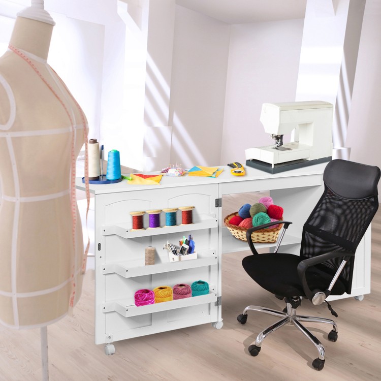 Folding sewing table with wheels, white MDF, features storage bins and an extra shelf for sewing machine and tools.