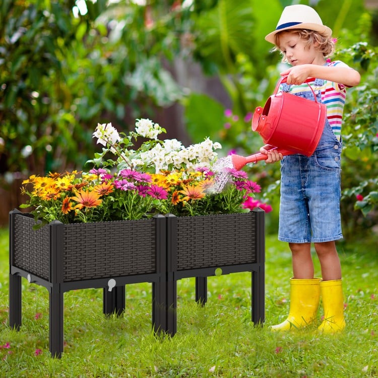 Elevated plastic raised garden bed planter kit with flowers, featuring a stylish rattan design for outdoor gardening.