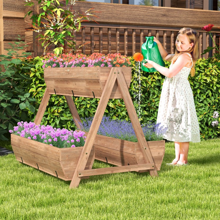A girl watering the vertical raised garden bed with 3 wooden planter boxes, showcasing vibrant flowers in natural fir.