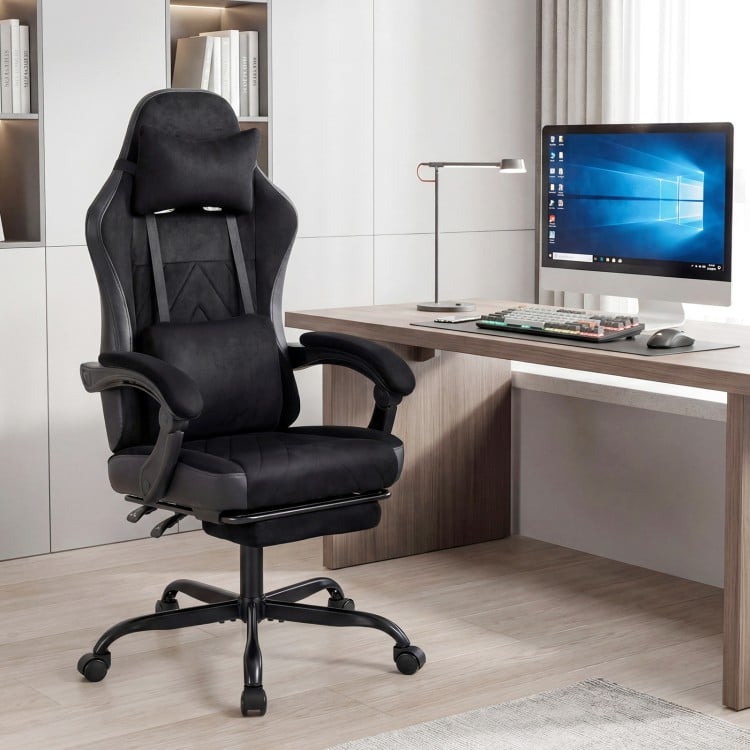 Height adjustable black gaming chair with headrest, lumbar support, and retractable footrest for ergonomic comfort.