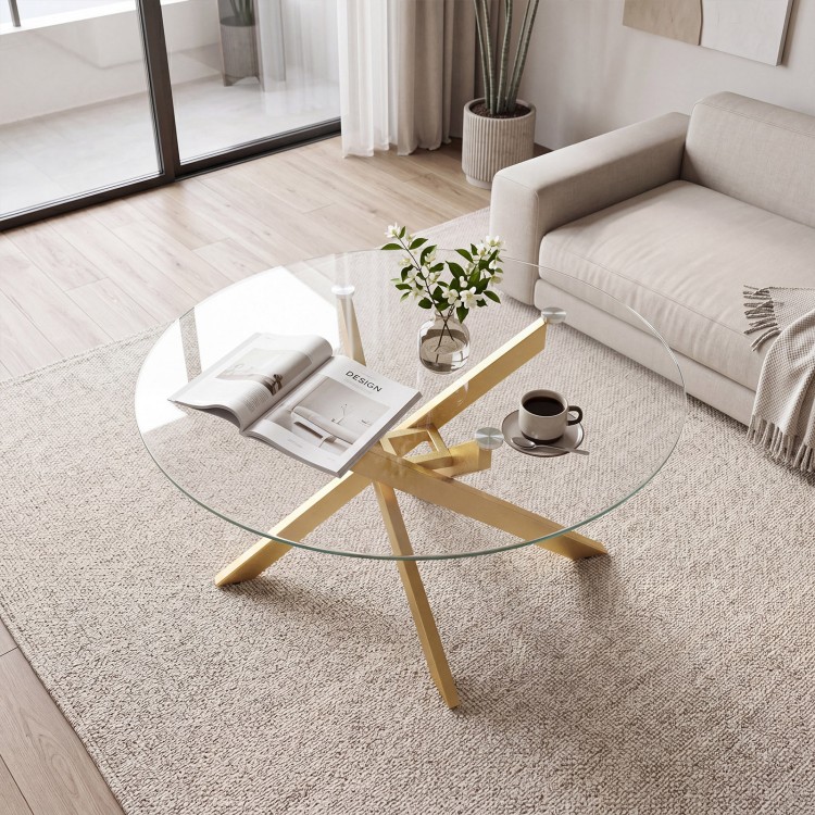 Round glass coffee table with a tempered glass top and geometric golden metal frame, perfect for modern living spaces.