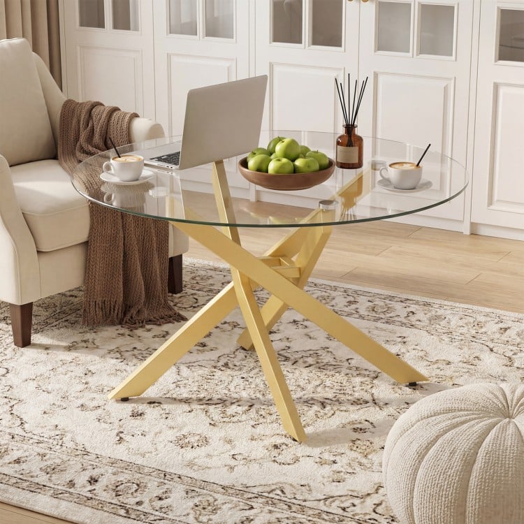 Round glass coffee table with a geometric gold metal frame, perfect for modern living spaces and easy maintenance.