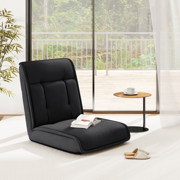Black folding floor chair with adjustable backrest, ideal for gaming, reading, or napping in a modern living space.