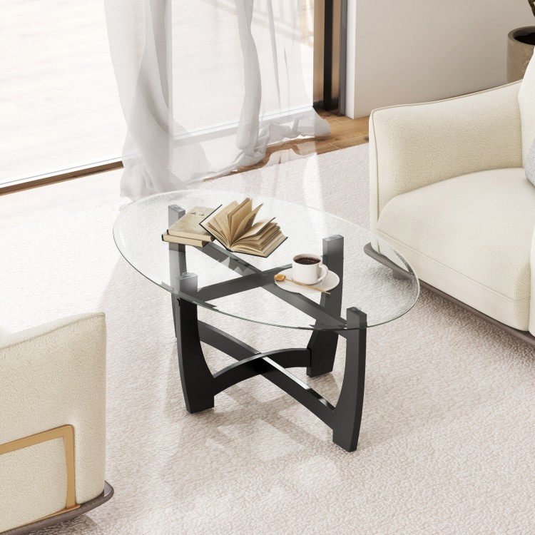 Oval coffee table with tempered glass top and rubber wood legs, featuring an X-shaped base, ideal for living room use.
