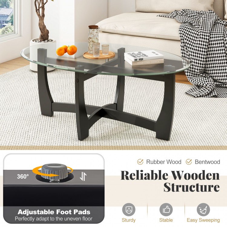Oval coffee table with tempered glass top and rubber wood legs, featuring an X-shaped base for easy cleaning and.