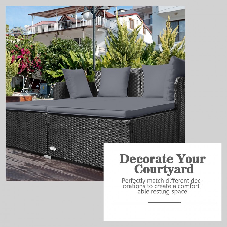 Spacious outdoor rattan daybed with gray upholstered cushions, ideal for creating a comfortable resting space.