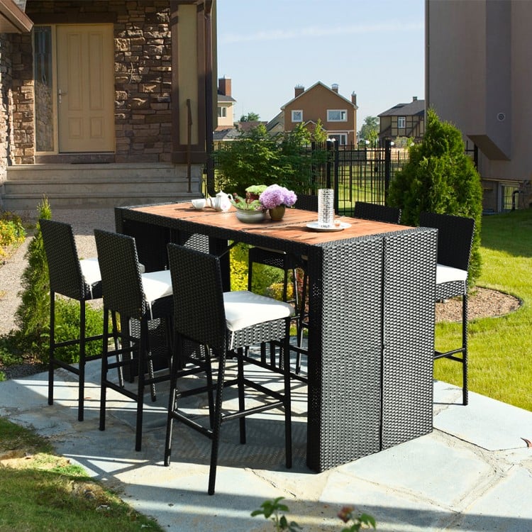 7-piece patio rattan wicker dining set featuring a table and 6 bar stools with cushions, perfect for outdoor dining.