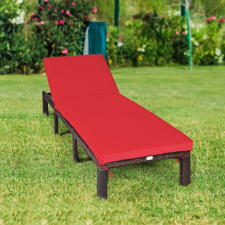 Red cushioned outdoor rattan chaise lounge with adjustable backrest, perfect for patio or poolside relaxation.