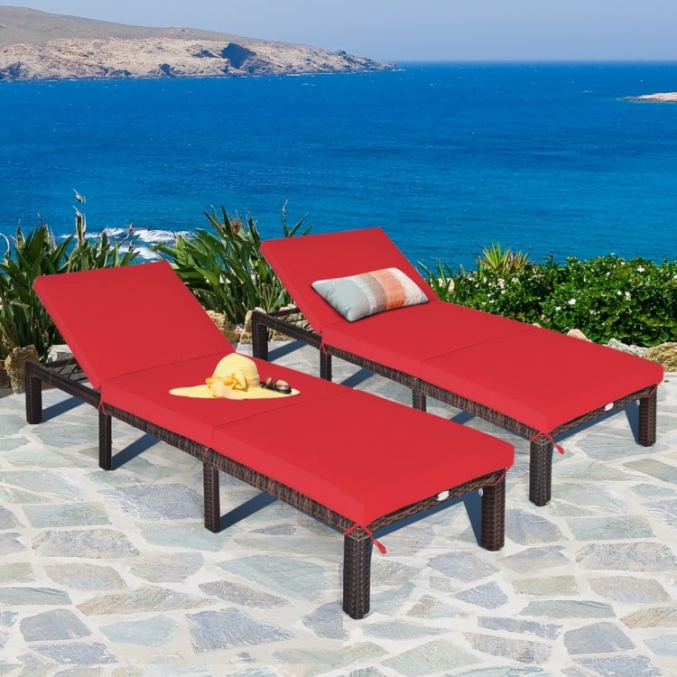 Adjustable outdoor rattan chaise lounge with red cushions, perfect for poolside or patio relaxation.
