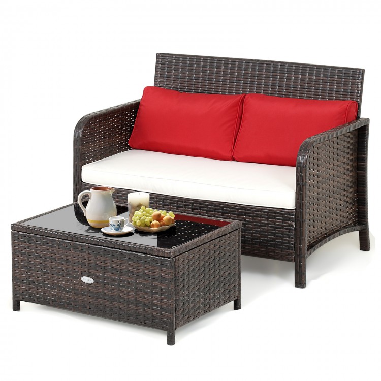 Wicker loveseat set with red cushions and coffee table, featuring black tempered glass for outdoor relaxation.