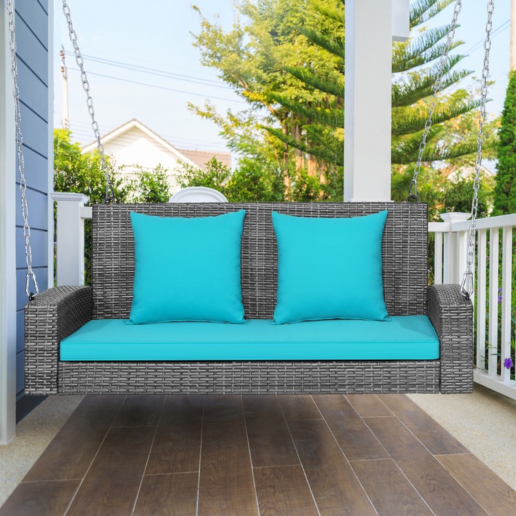 Two-person patio PE wicker hanging swing bench with turquoise cushions, featuring sturdy chains and ergonomic armrests.