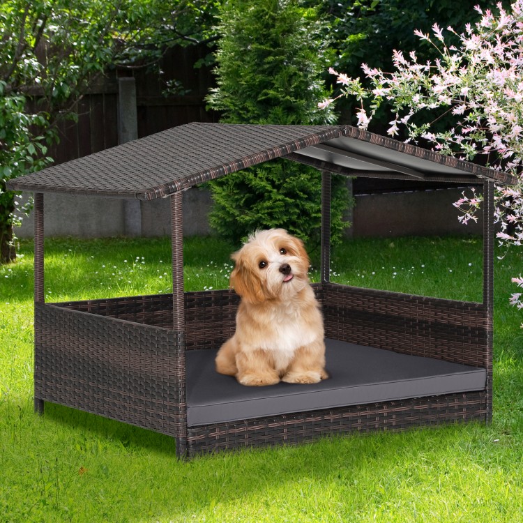 Wicker dog house with weatherproof roof and soft cushion, perfect for outdoor use in yard or garden.