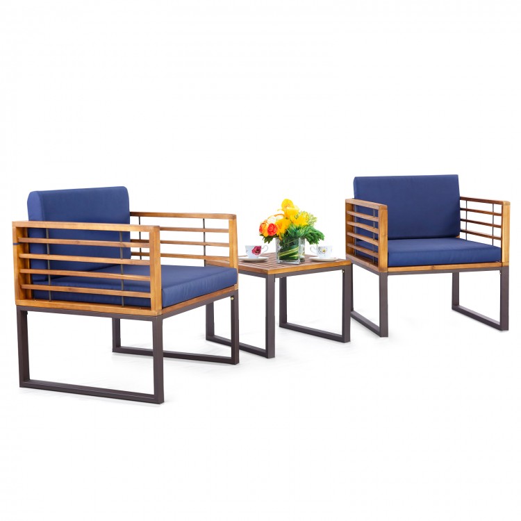 Two navy cushioned armchairs and a coffee table from a 3-piece patio acacia wood conversation set for outdoor use.