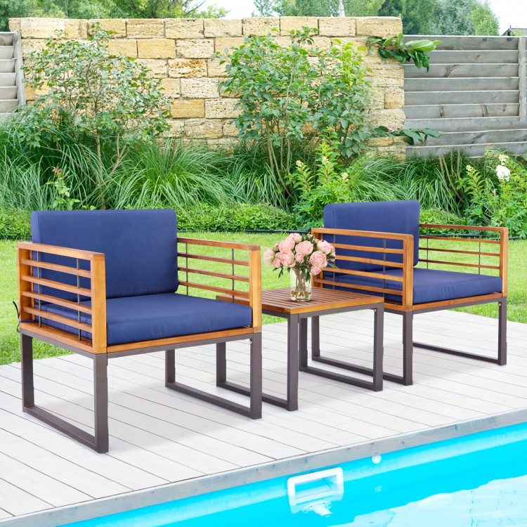 Acacia wood patio conversation set with navy cushioned armchairs and coffee table, perfect for outdoor relaxation.