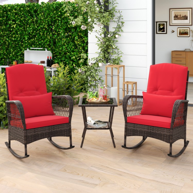 Two red cushioned rocking chairs with a 2-tier coffee table, made of PE rattan, perfect for outdoor relaxation.