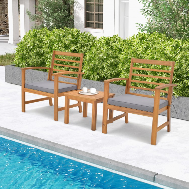 Outdoor furniture set featuring sturdy acacia wood chairs with gray cushions, perfect for poolside relaxation.