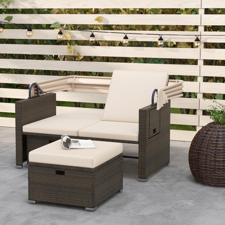 Outdoor patio rattan daybed with beige cushions, adjustable backrests, and retractable canopy for backyard relaxation.