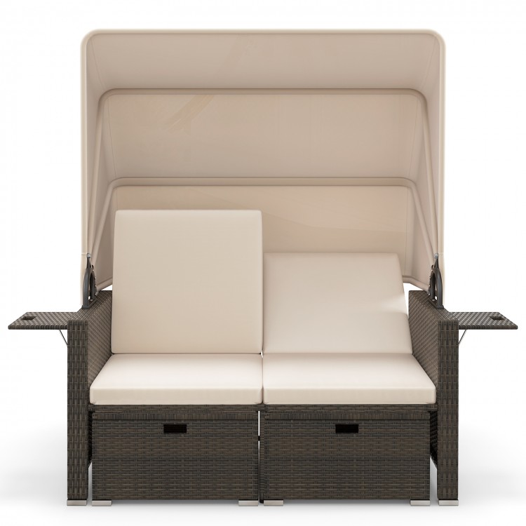 Outdoor patio rattan daybed in beige with retractable canopy and adjustable backrests, ideal for backyard relaxation.