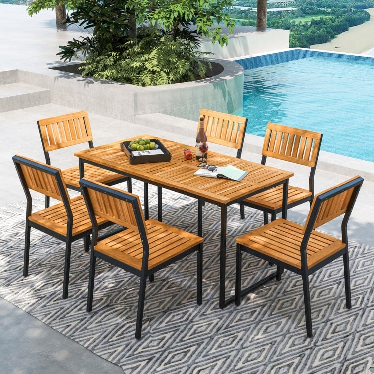 Acacia wood dining table set with six matching chairs, perfect for outdoor dining and gatherings by the pool.