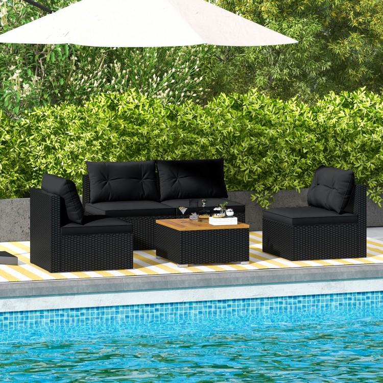 5-piece outdoor furniture set in black with soft cushions and solid tabletop, perfect for poolside relaxation.