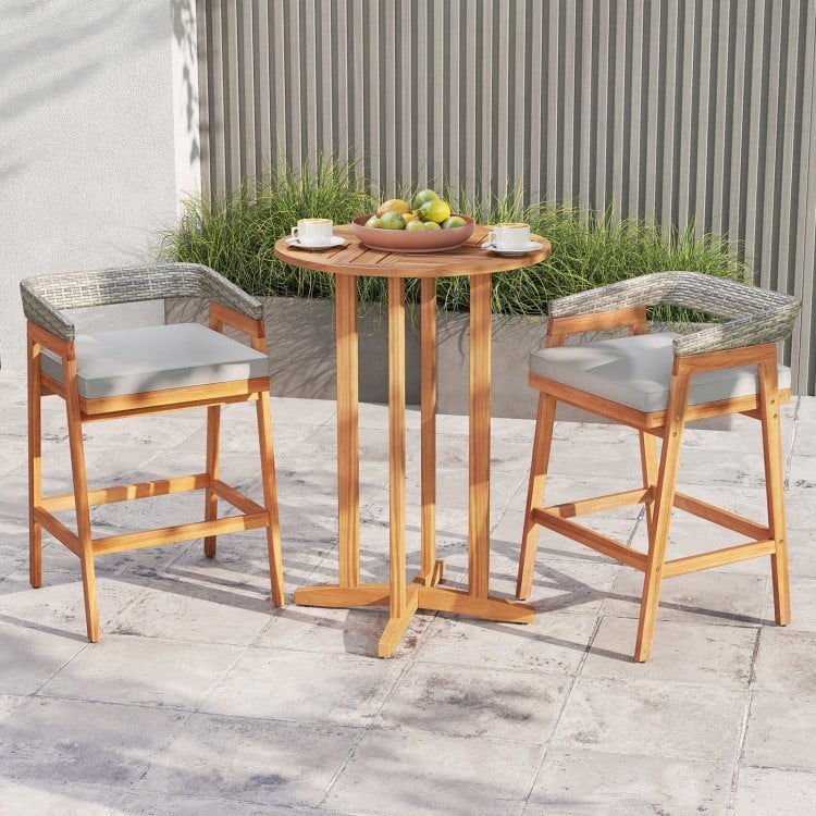 Set of 2 gray patio bar stools with acacia wood frames, PE wicker backrests, and soft cushions for outdoor comfort.