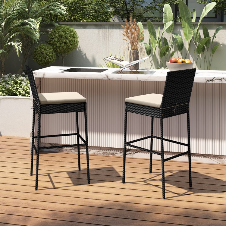 Set of 2 patio wicker barstools with backrest and footrest, featuring beige cushions, ideal for backyard or poolside.
