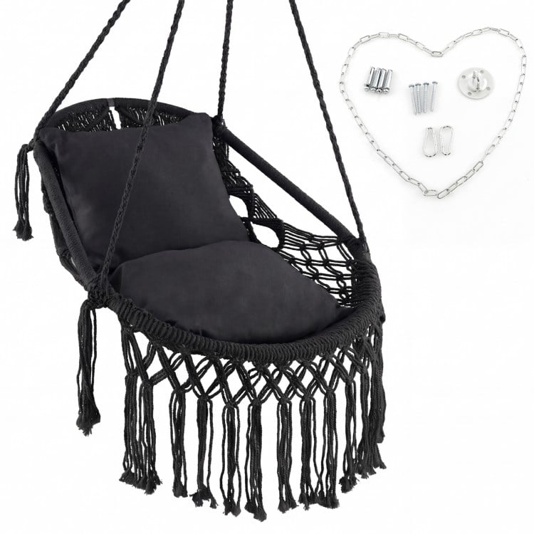 Hanging hammock chair in black with soft cushions, tassels, and sturdy rope chain, suitable for indoor and outdoor use.