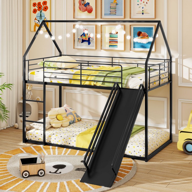House-shaped black metal twin over twin low bunk bed with slide, safety guardrails, and ample clearance for kids' play.