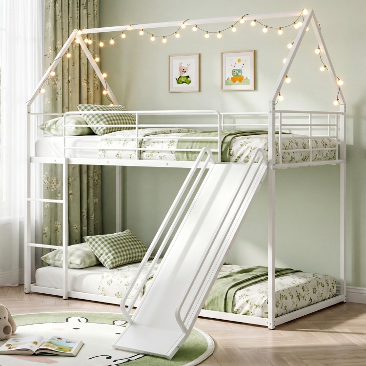 House-shaped metal twin over twin low bunk bed in white with slide, safety guardrails, and decorative design for kids.