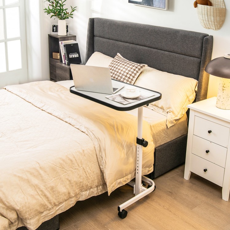 Rolling overbed bedside table with adjustable height, tiltable tabletop, and wheels for easy maneuverability.