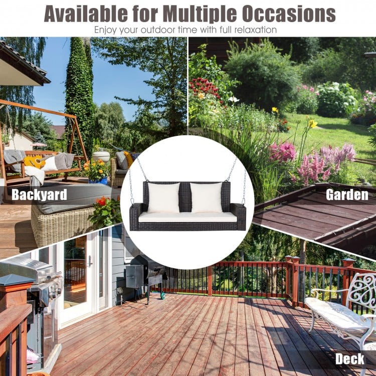 2-person patio rattan porch swing with white cushions, perfect for relaxing in the backyard or garden.