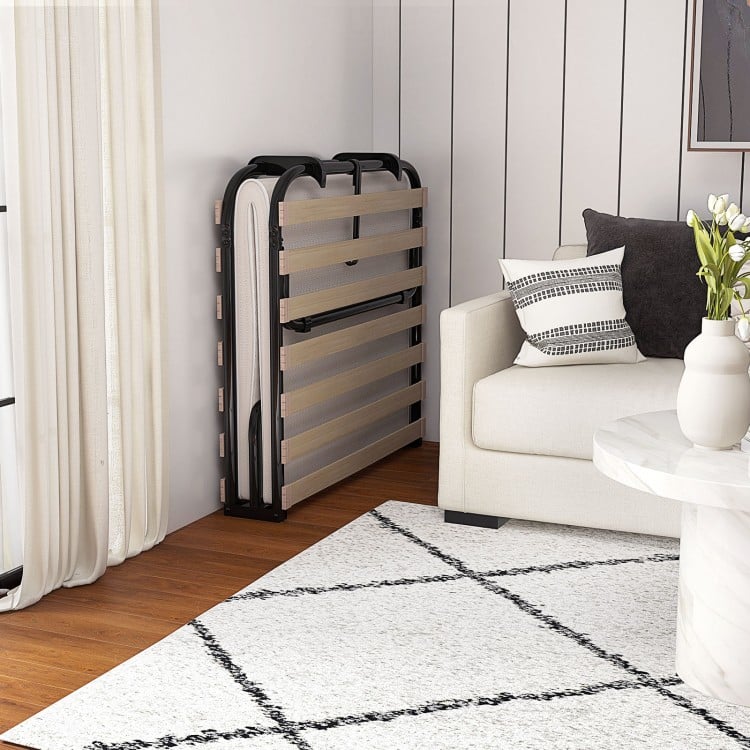 Twin size folding guest bed with memory foam mattress, compactly stored against the wall for easy access and.