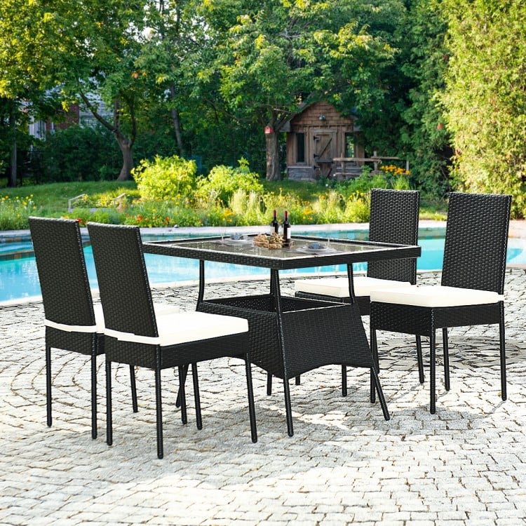 5-piece outdoor patio rattan dining set with glass top and cushions, perfect for family gatherings by the poolside.